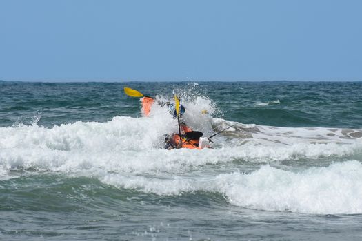 Kayak crashes through waves as two men attempt to go ocean fishing, Mossel Bay, South Africa