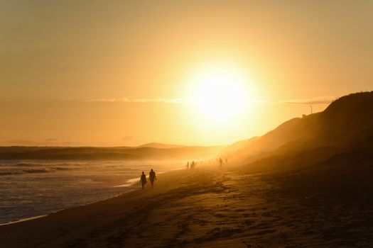 An elderly couple walking on the beach during the afternoon sunset, Mossel Bay, South Africa