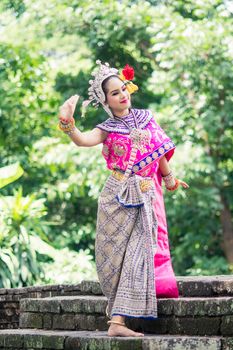 Asian woman wearing typical, traditional Thai Dress. It is literally means "Thai outfit", National costume.
