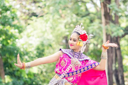 Asian woman wearing typical, traditional Thai Dress. It is literally means "Thai outfit", National costume.
