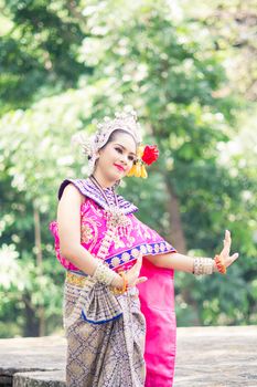 Asian woman wearing typical, traditional Thai Dress. It is literally means "Thai outfit", National costume.
