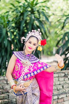 Asian woman wearing typical, traditional Thai Dress. It is literally means "Thai outfit", National costume.
