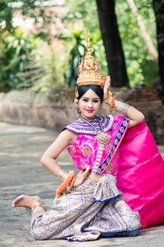 Asian woman wearing typical, traditional Thai Dress. It is literally means "Thai outfit", National costume.
