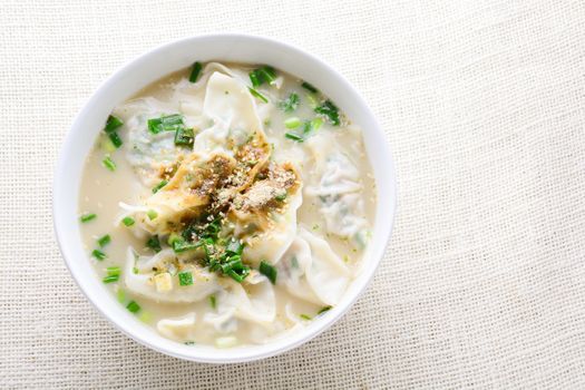 Wonton soup with spring onion served in a white bowl, selective focus
