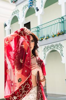 Red Indian Costume Beautiful Girl, face partially covered with saree. Portrait of Traditional woman in sari dress.
