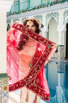 Red Indian Costume Beautiful Girl, face partially covered with saree. Portrait of Traditional woman in sari dress.
