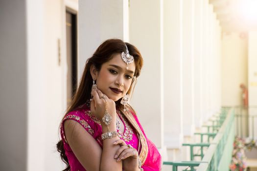 Pink and Yellow Indian Costume Beautiful Girl, face partially covered with saree. Portrait of Traditional woman in sari dress.
