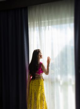 Pink and Yellow Indian Costume Beautiful Girl, face partially covered with saree. Portrait of Traditional woman in sari dress.
