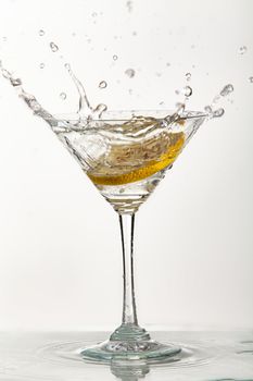 Glass of water, lemon and watersplashes on a black studio background