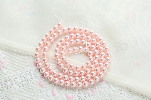 pearl necklace on white fabric background, Close up shot of glass pearls 
