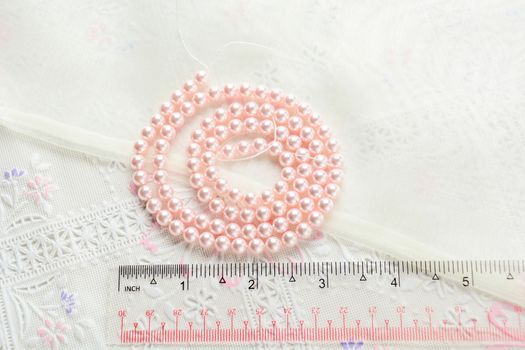 pearl necklace on white fabric background, Close up shot of glass pearls 
