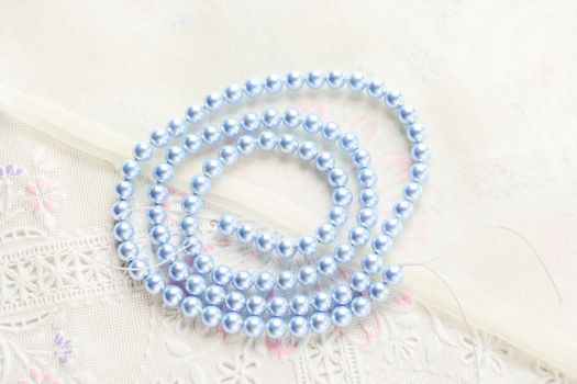 pearl necklace on white fabric background, Close up shot of glass pearls 
