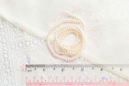 pearl necklace on white fabric background, Close up shot of glass pearls 
