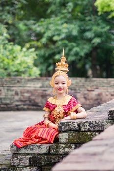 Asian woman wearing typical, traditional Thai Dress. It is literally means "Thai outfit", National costume.
