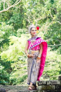 Asian woman wearing typical, traditional Thai Dress. It is literally means "Thai outfit", National costume.
