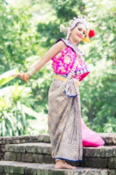 Asian woman wearing typical, traditional Thai Dress. It is literally means "Thai outfit", National costume.
