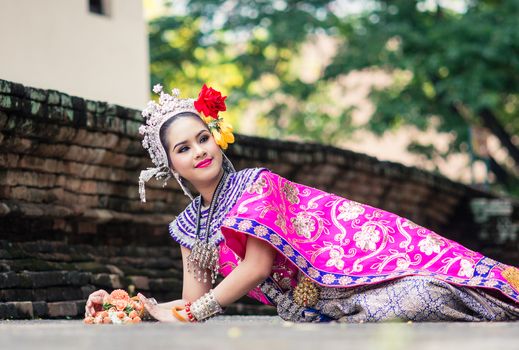 Asian woman wearing typical, traditional Thai Dress. It is literally means "Thai outfit", National costume.
