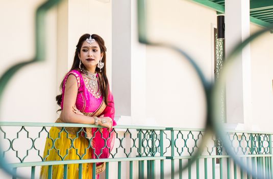 Pink and Yellow Indian Costume Beautiful Girl, face partially covered with saree. Portrait of Traditional woman in sari dress.
