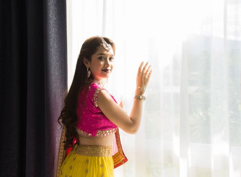 Pink and Yellow Indian Costume Beautiful Girl, face partially covered with saree. Portrait of Traditional woman in sari dress.
