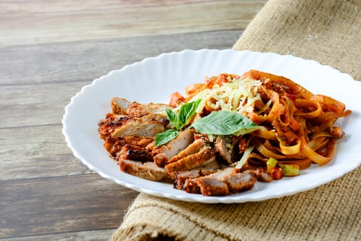 Steak meat with spaghetti and cheese on wood background.
