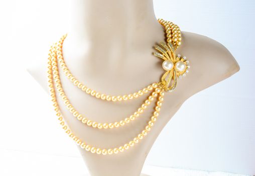 Pearl necklace on mannequin and on white background
