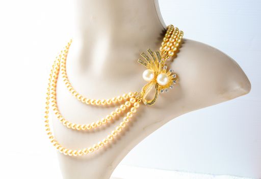 Pearl necklace on mannequin and on white background
