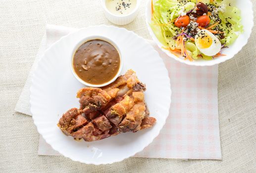 Deep fried pork knuckle with mushroom gravy source, fresh vegetable and salad cream source