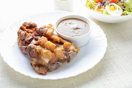 Deep fried pork knuckle with mushroom gravy source, fresh vegetable and salad cream source