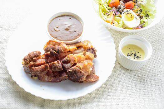 Deep fried pork knuckle with mushroom gravy source, fresh vegetable and salad cream source