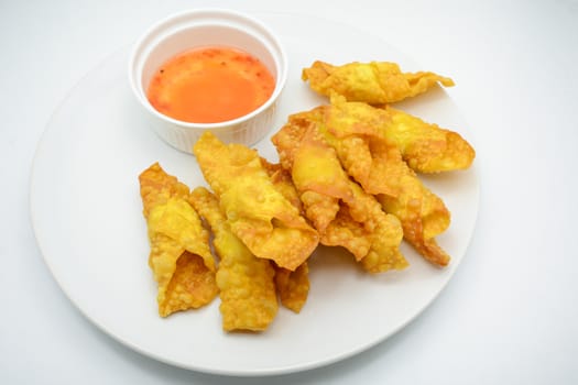 Deep Fried Won ton on white plate with dip source