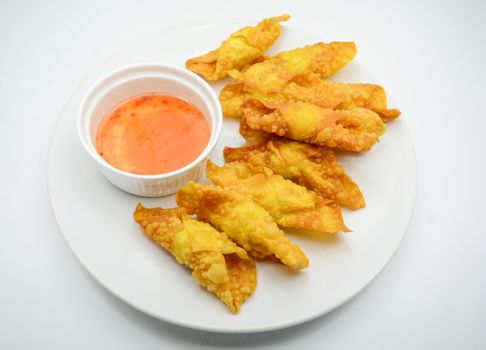 Deep Fried Won ton on white plate with dip source