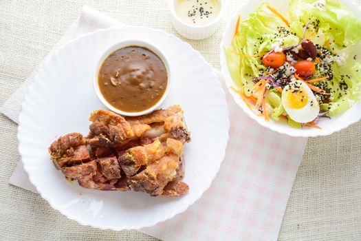 Deep fried pork knuckle with mushroom gravy source, fresh vegetable and salad cream source