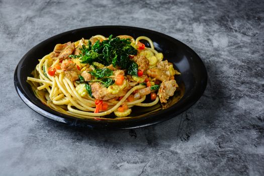 Hot and spicy chicken spaghetti, topping with crispy sweet basil and sliced baby corn
