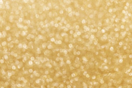 Golden festive glitter background with defocused lights