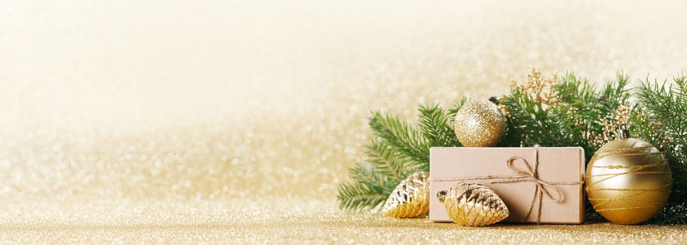 Christmas toys, decorations, present gift box wrapped in kraft paper on golden glitter background, copy space