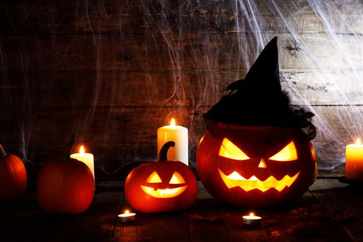 Jack O Lantern Halloween pumpkin with witches hat , spiders on web and burning candles