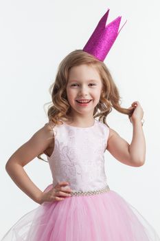 Happy small princess girl in pink dress and crown on white background