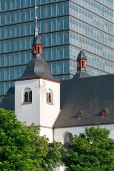 Old church and monastery St. Heribert in front of a modern office building, Cologne, Germany