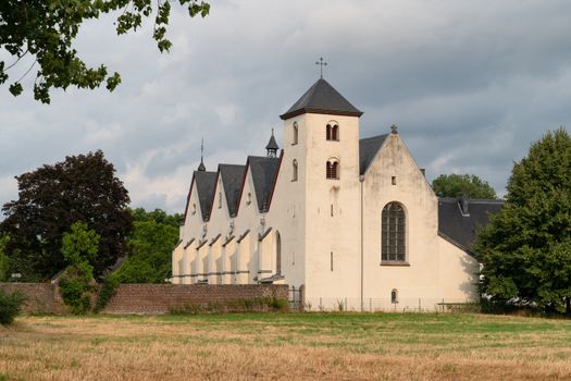 Panoramic image of the old parish church of Cologne Duennwald on a cloudy day, Germany
