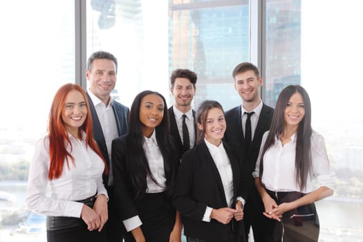 Portrait of business team of men and women in office with view on skyscrapers