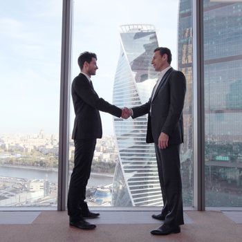 Business people shaking hands, finishing up a meeting in office