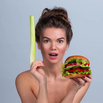 Healthy food or junk food choice concept for your healthy life, girl holding celery and hamburger