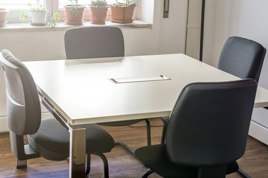 four empty chairs in a conference room with a white table