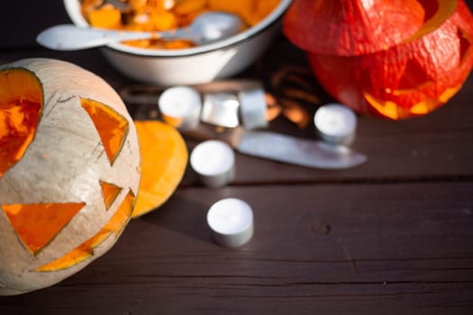 Preparing for halloween , carved jack o lantern pumpkin candles and knife on wooden table