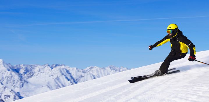 Professional alpine skier skiing downhill in high mountains of Alps