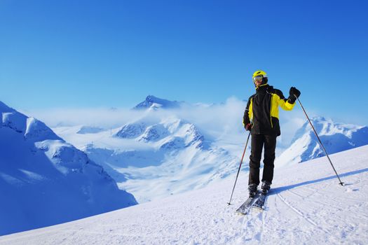 Skier standing alone and looking at panoramic view at Alps mountains