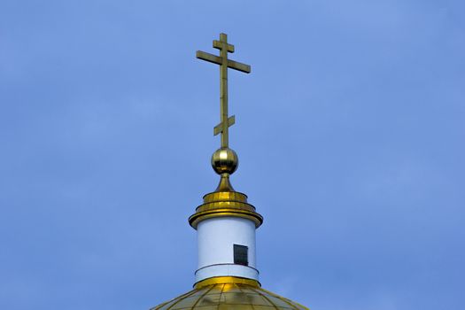 
The upper part of the gilded dome of the temple with a cross.