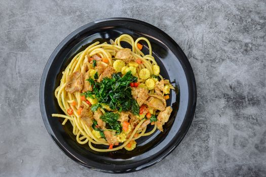 Hot and spicy chicken spaghetti, topping with crispy sweet basil and sliced baby corn
