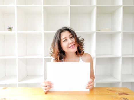 Attractive beautiful woman holding blank white paper.
