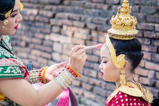 Asian woman wearing typical, traditional Thai Dress. It is literally means "Thai outfit", National costume.
